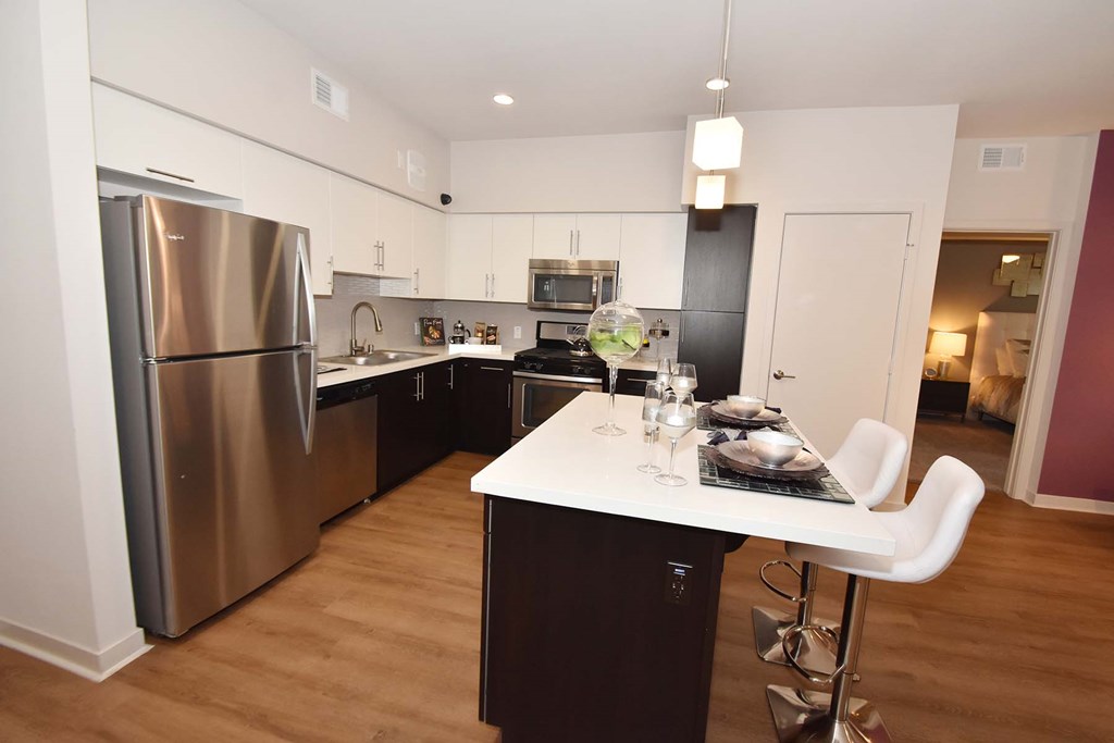 A modern kitchen with a dining table set for two.