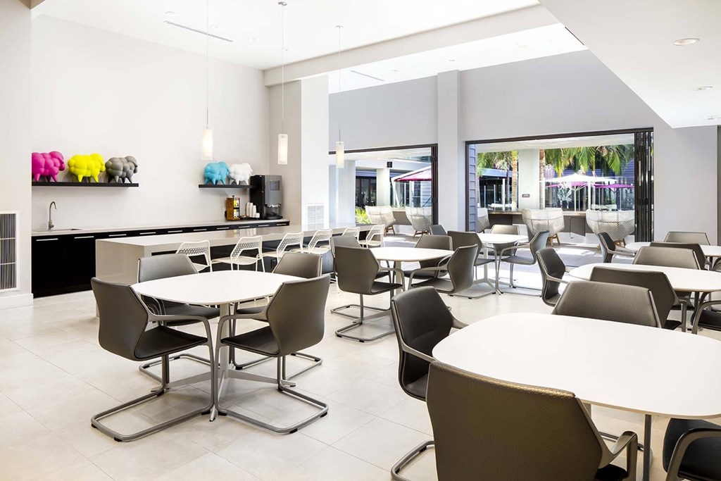 A white table with a black chair in a room with a white ceiling.