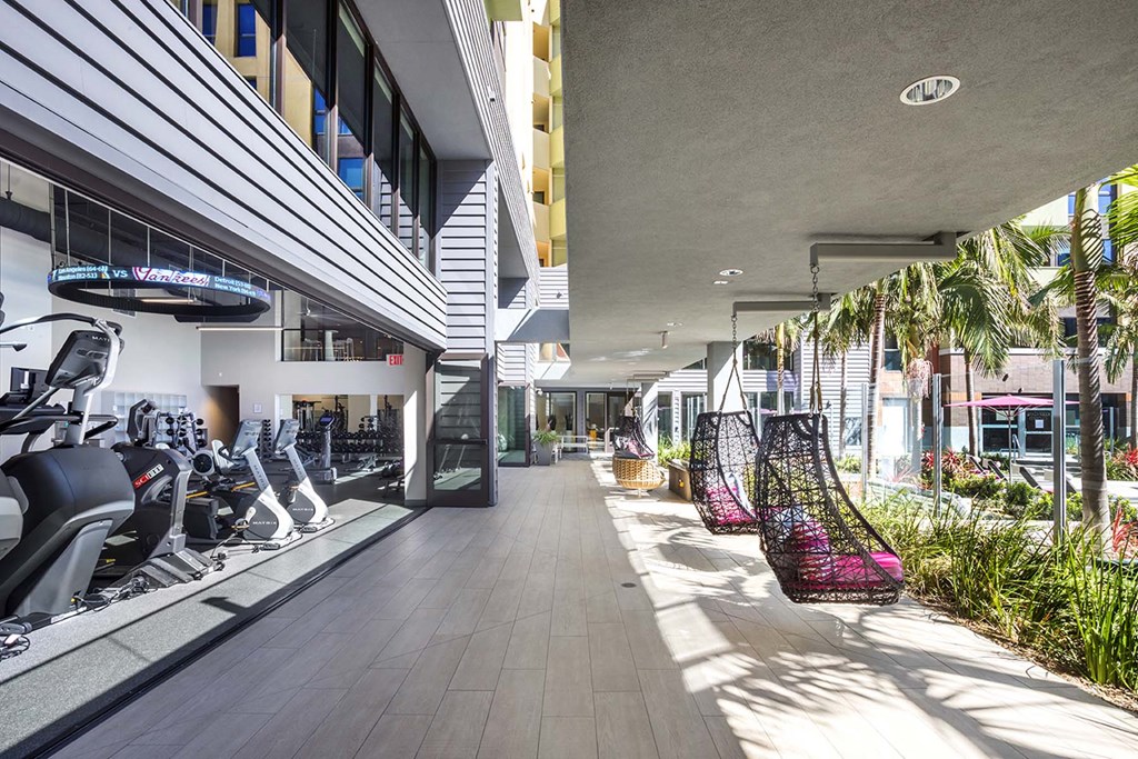A gym with exercise equipment and a row of hanging chairs.