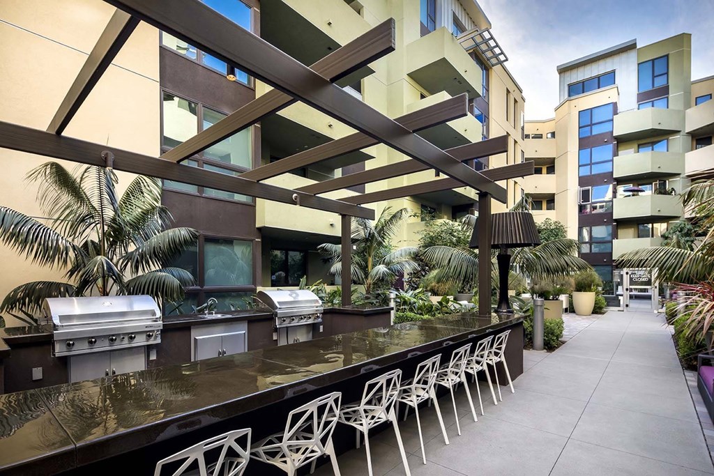 A patio with a bar and chairs is surrounded by buildings.