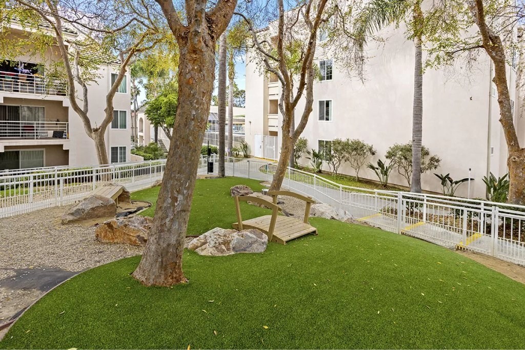 A tree in a grassy area in front of a building.