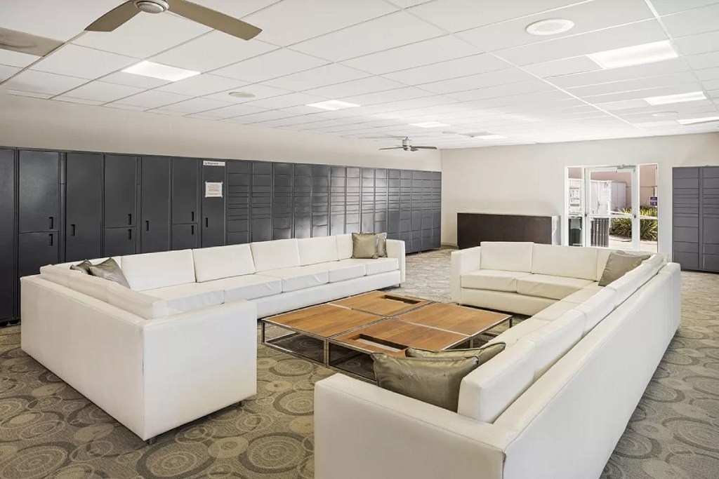 A spacious room with white furniture and a ceiling fan.