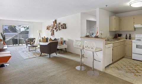 A kitchen with a bar stool and a table with a chair.
