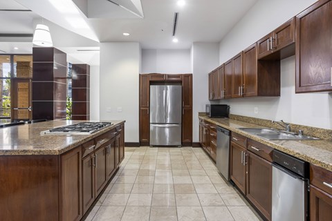 A kitchen with brown cabinets and a stainless steel refrigerator.at Costa Verde Village Apartments, California