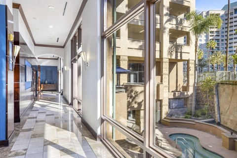 A long hallway with a pool outside the window.at Costa Verde Village Apartments, San Diego, 92122