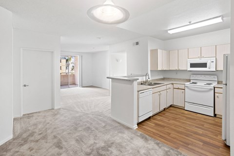 A kitchen with white appliances and wooden floors.at Costa Verde Village Apartments, California, 92122
