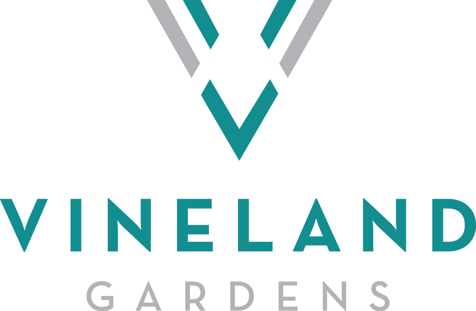 A logo with the words "Vineland Gardens" in front of it.