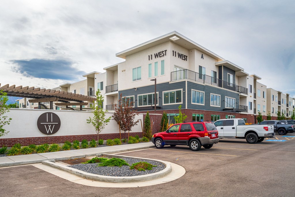 a parking lot with a red truck parked in front of a building with the words in west