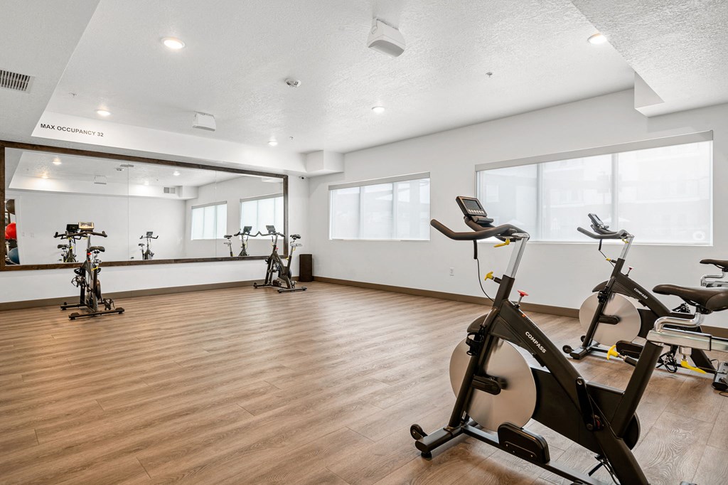 a gym with white walls and hardwood flooring