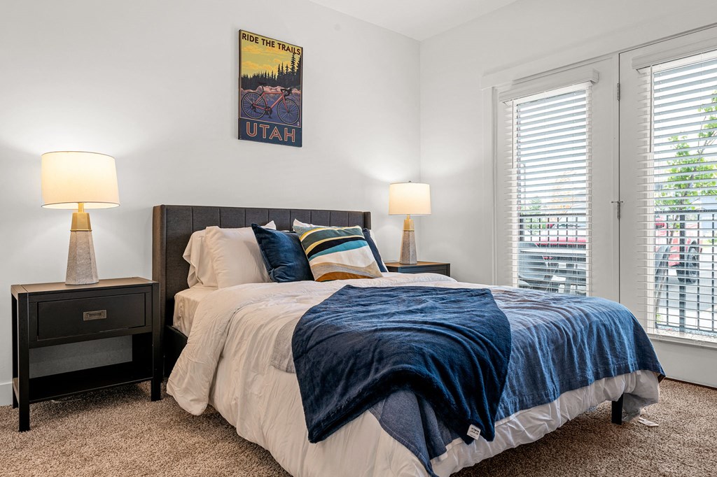 a bedroom with a bed and two windows