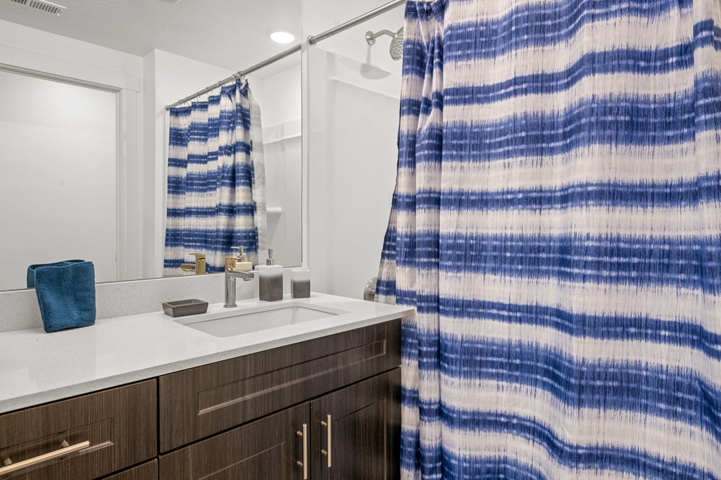 a bathroom with a sink and shower in a 555 waverly unit