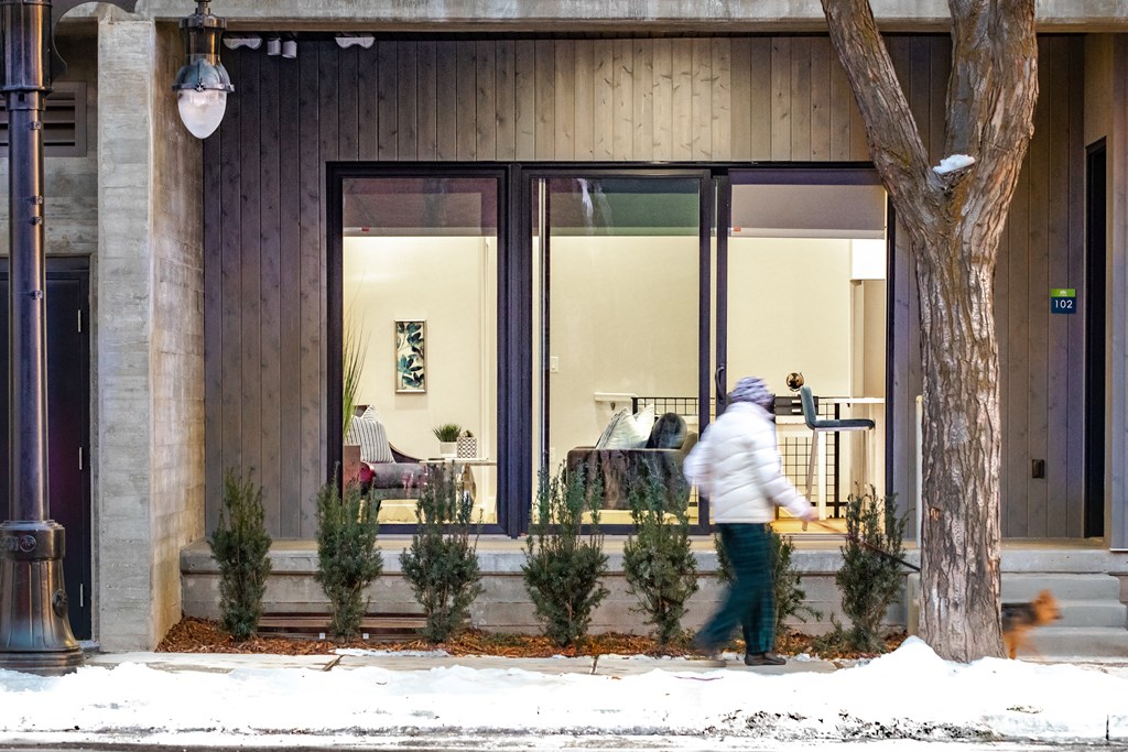 a person walking in the snow outside of a building