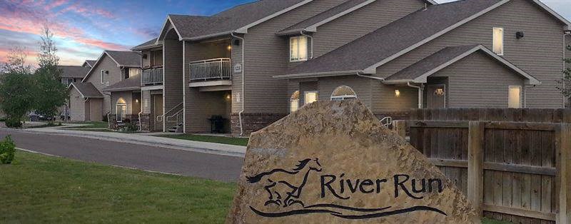 A sign in front of a building that says River Run.