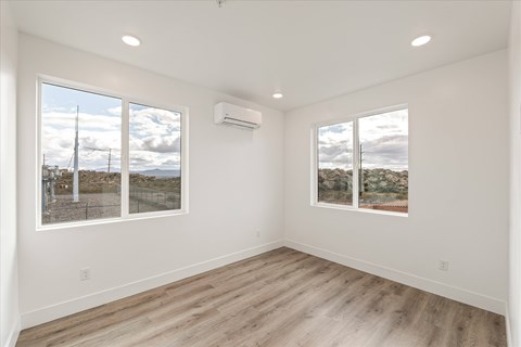 A spacious room with a view of the outdoors through large windows.