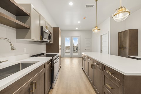 A modern kitchen with dark brown cabinets and white countertops.