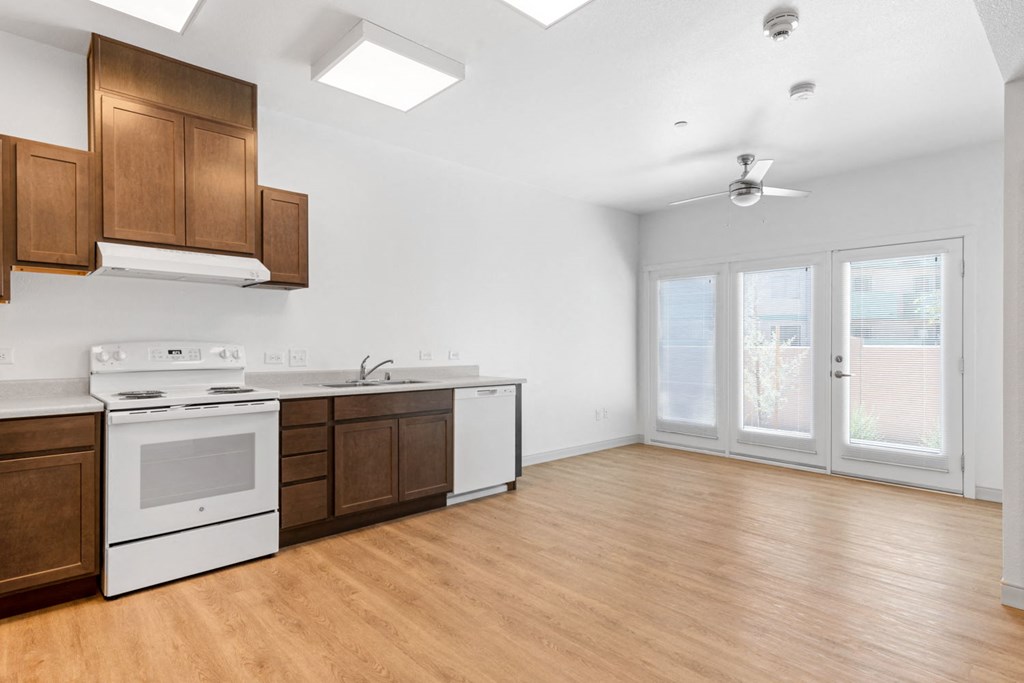 a kitchen and living room with wood floors and white walls