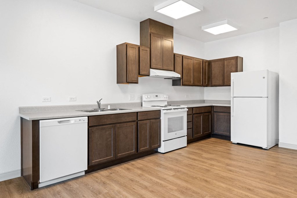 a kitchen with dark wood cabinets and white appliances