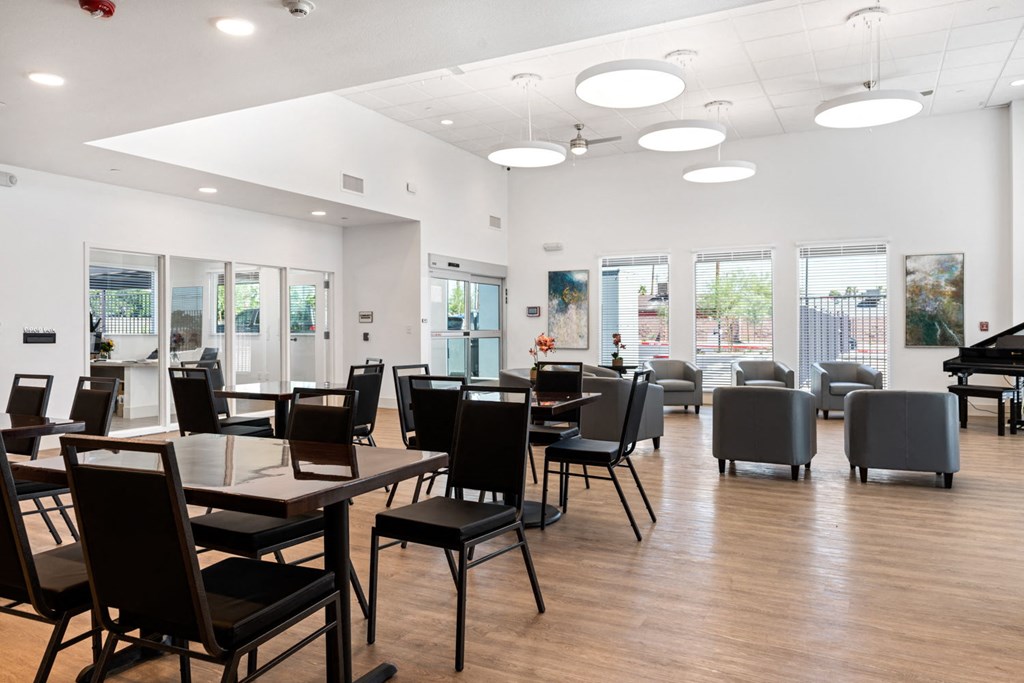 a large room with tables and chairs and a piano in the corner