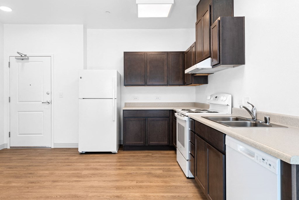 a kitchen with white appliances and dark wood cabinets