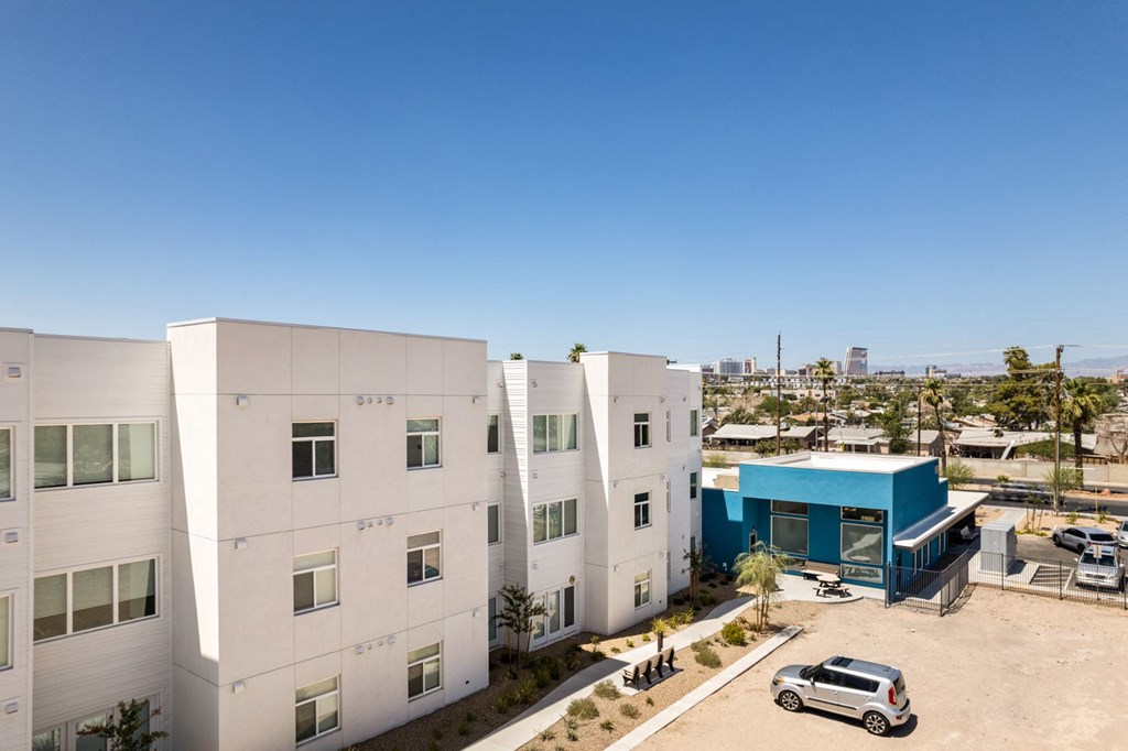 a large white building with a blue building next to it