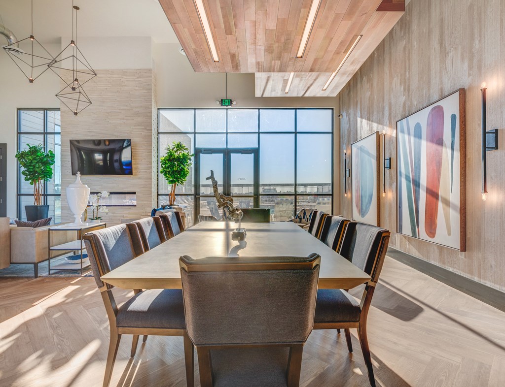 A modern dining room with a long table and chairs.