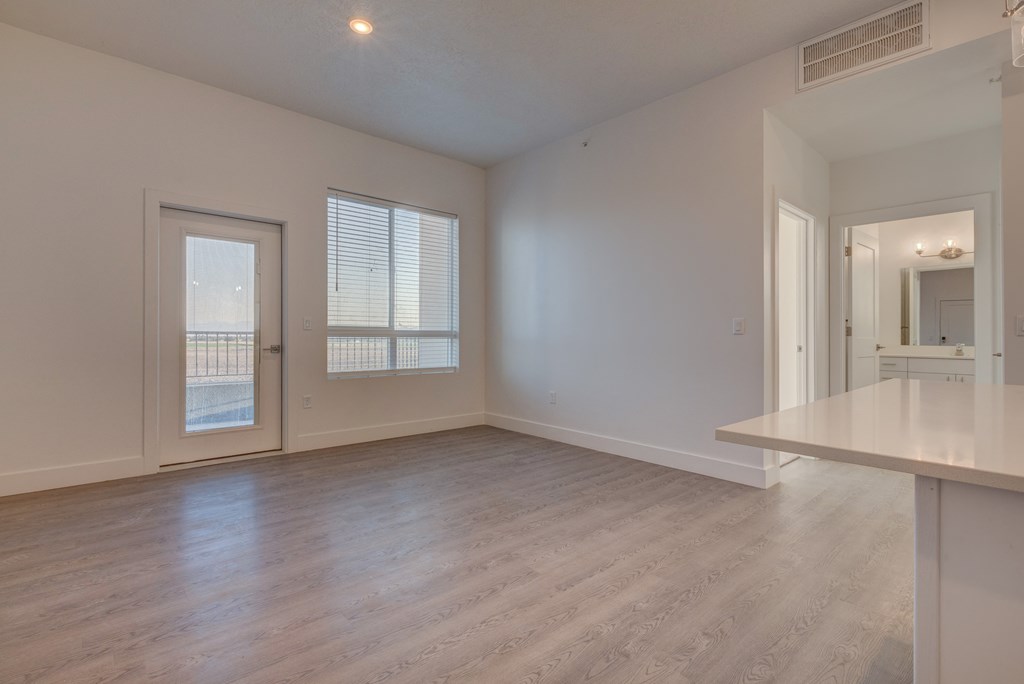 A spacious room with a door, a window, and a long table.