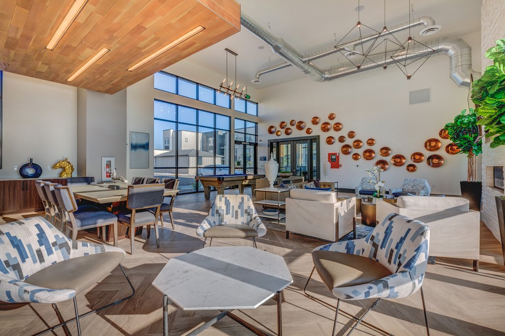 A modern living room with a wooden ceiling and a variety of seating options.