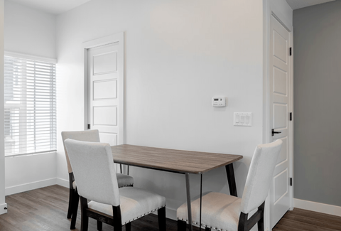 a dining room with a wooden table and white chairs