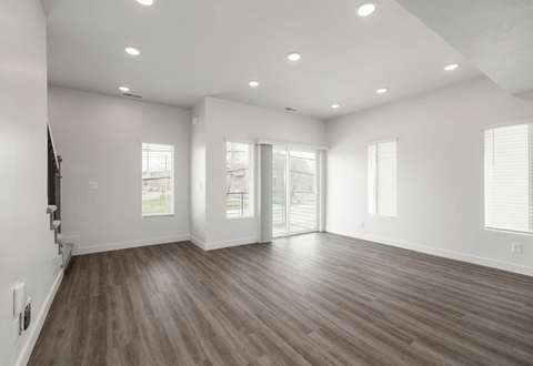 an empty living room with white walls and wood floors