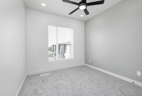 an empty room with a ceiling fan and a window