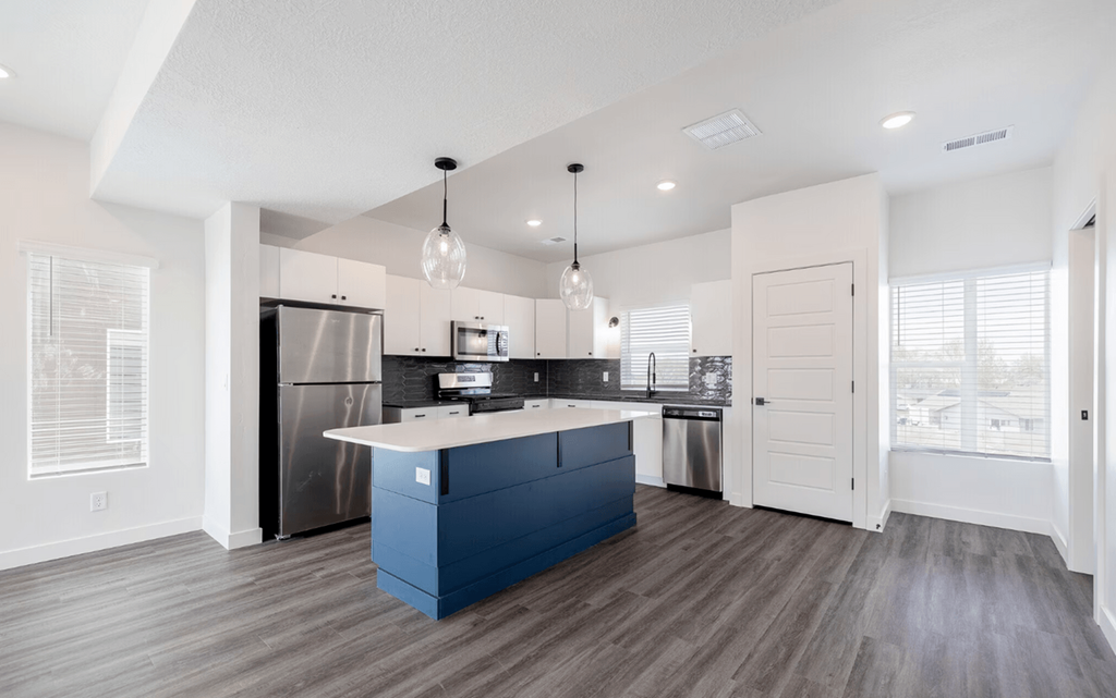 a kitchen with a blue island and a stainless steel refrigerator