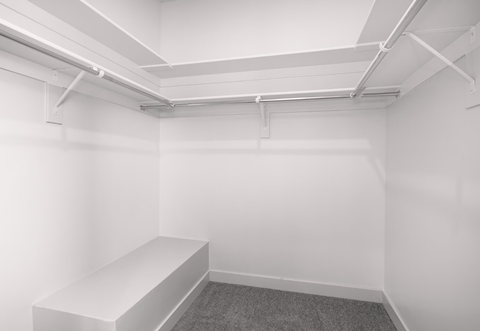 a small room with a white wall and a white bench