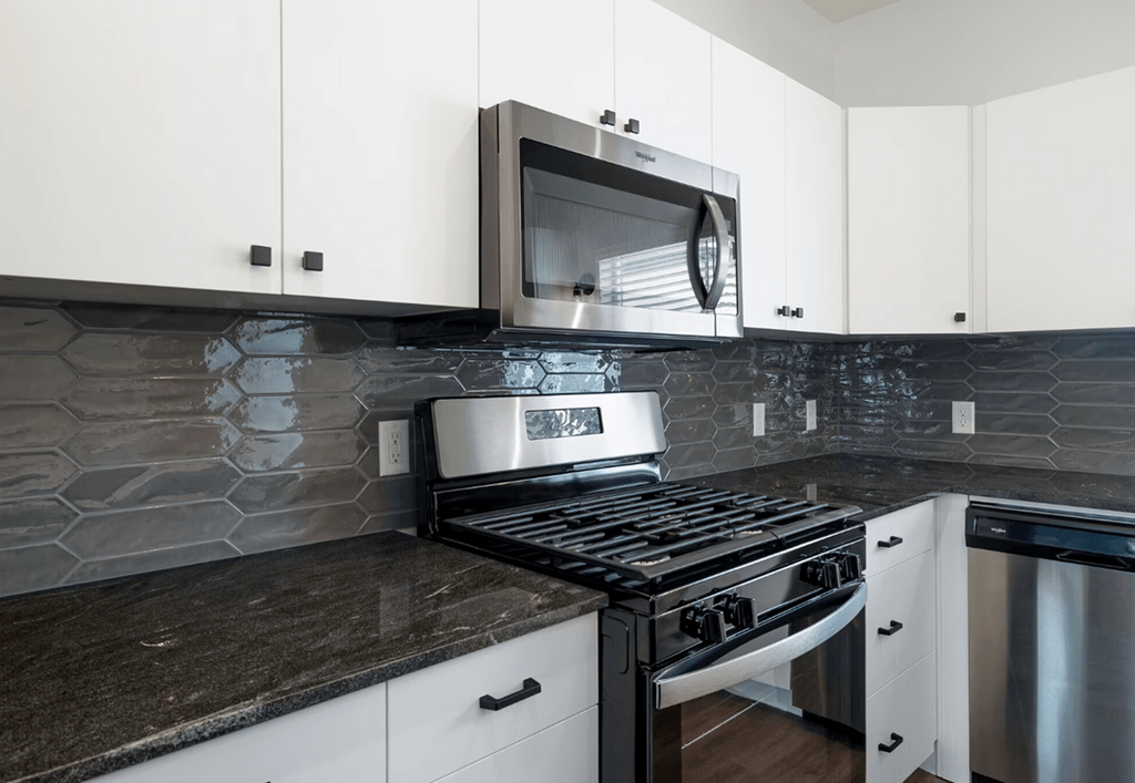 a kitchen with white cabinets and a stove and a microwave