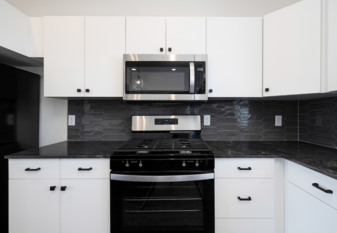 a black and white kitchen with a stove and a microwave