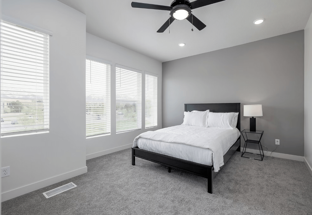 a bedroom with a large bed and a ceiling fan