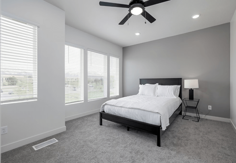 a bedroom with a large bed and a ceiling fan