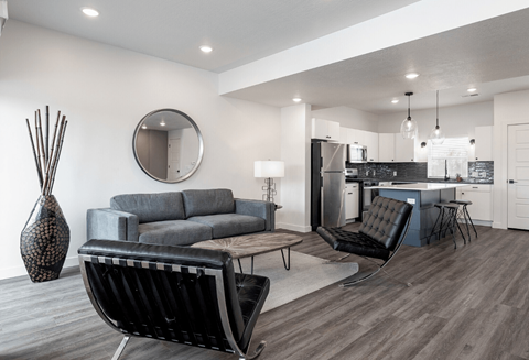 a living room with a couch and a chair and a kitchen with a