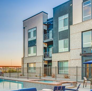 A modern apartment building with a pool in front.