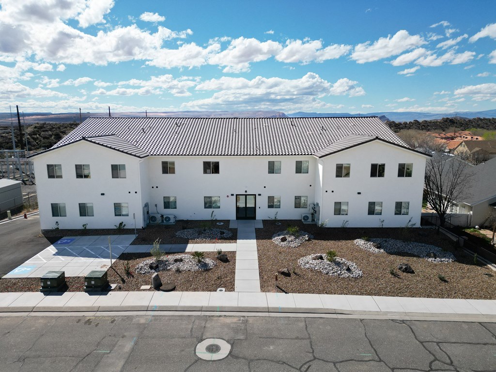 an aerial view of a white house with a courtyard and a blue sky