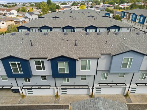 A row of houses with grey roofs and blue and white walls.