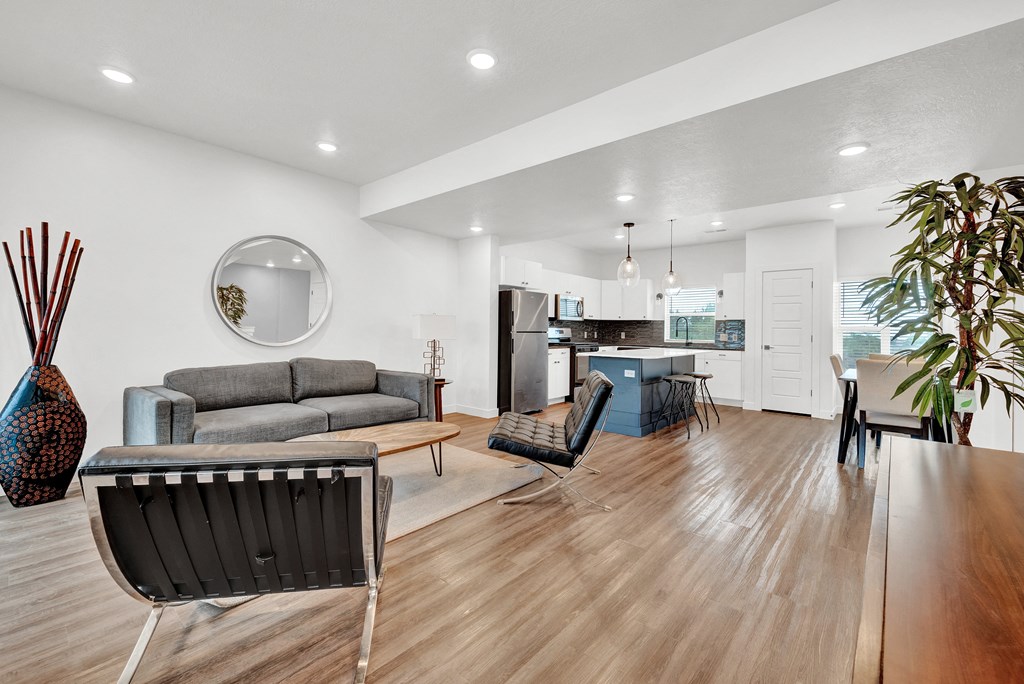 a living room with a couch and a chair and a kitchen with a