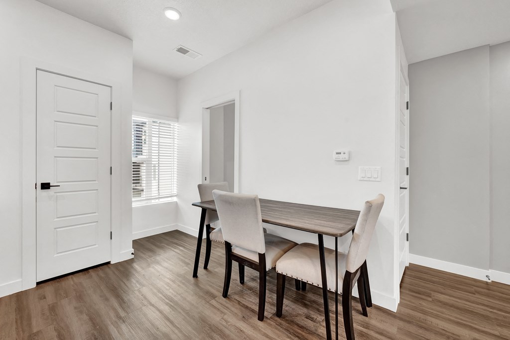a dining room with a wooden table and chairs