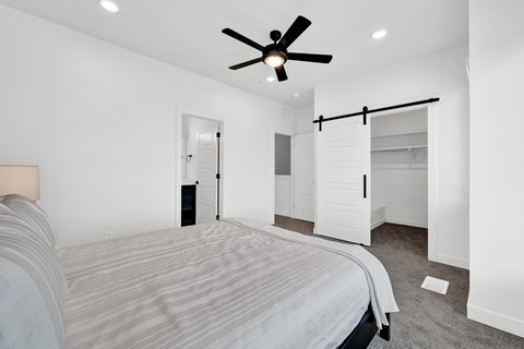 a bedroom with a large bed and a ceiling fan