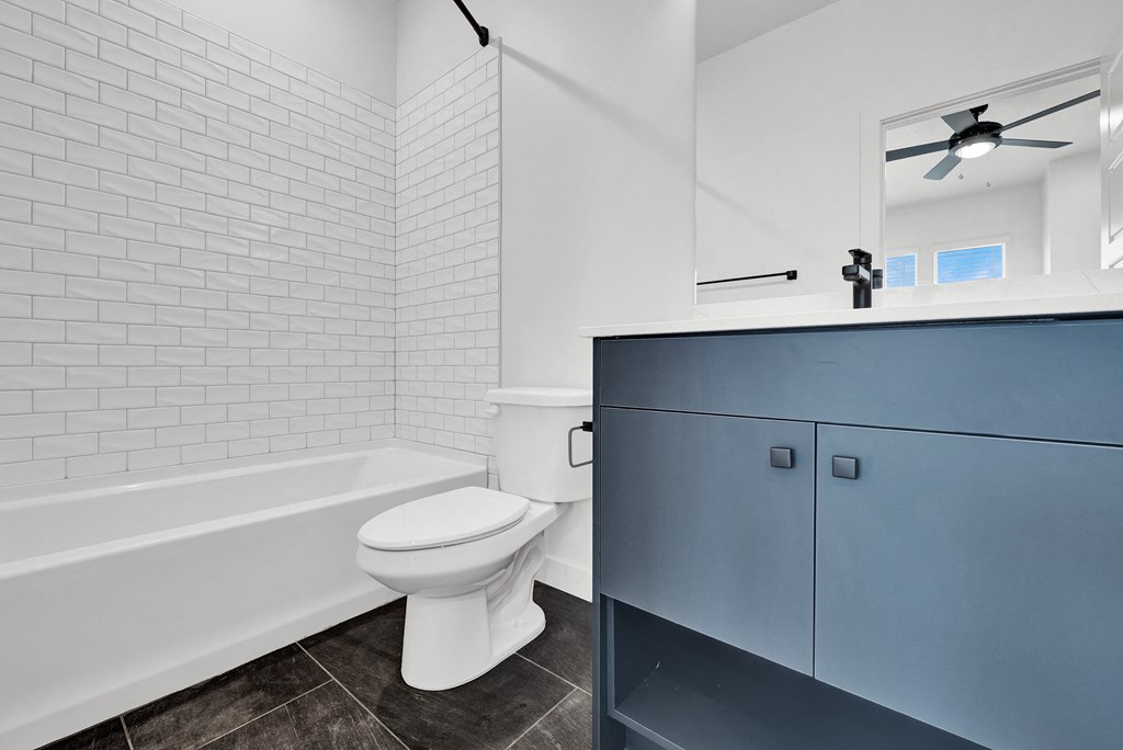 a bathroom with a white toilet and a tub and a sink