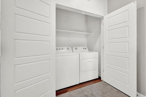 a washer and dryer in a laundry room with white doors