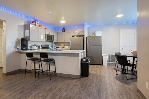A kitchen with a bar area and a refrigerator.
