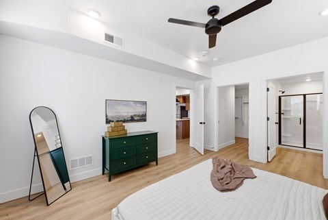 A bedroom with a white bed and a green dresser.