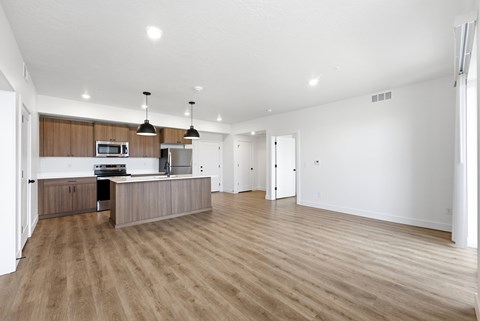 A spacious kitchen with wooden floors and a modern design.