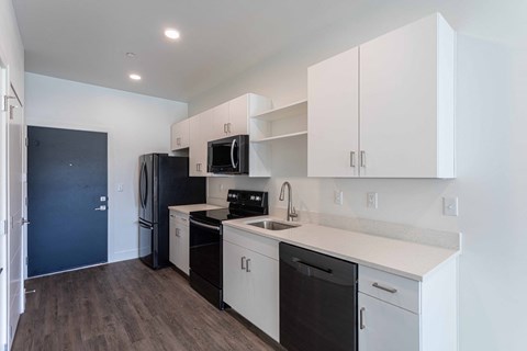 a kitchen with white cabinets and black appliances and a black refrigerator