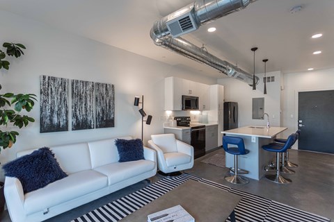 A modern living room with a white couch and a bar area.